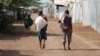 FILE - Men carry bags of food aid at the Kakuma refugee camp in northern Kenya, March 6, 2018. 