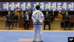 FILE - A North Korean participant in a national Taekwondo festival is judged in front of a sign in Korean that reads “National Taekwondo Festival for Celebrating Day of the Sun” at the Taekwondo Hall in Pyongyang, North Korea, April 7, 2012.