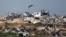 ARCHIVO - Un pájaro vuela sobre edificios destruidos en el norte de Gaza, en medio de un alto el fuego entre Israel y Hamás, visto desde Israel, el 2 de marzo de 2025. 