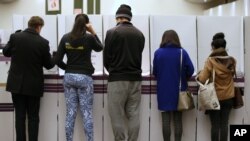 Voters fill in their ballots at a polling station at Town Hall in Sydney, Saturday, July 2, 2016. 