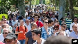 People walk inside Gezi Park at Taksim Square in Istanbul, Turkey, July 8, 2013. Istanbul's governor re-opened the park that was at the center of weeks of anti-government protests.