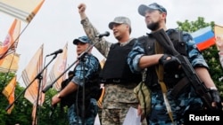 FILE - Self-styled governor of Luhansk region Valery Bolotov (C) delivers a speech during a rally to mark and celebrate the announcement of the results of the referendum on the status of Luhansk region in Luhansk, May 12, 2014.