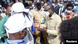 Benin's President Patrice Talon talks to African Union observers after casting his ballot at a polling station in Cotonou, Benin, Apr. 11, 2021.
