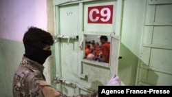 A member of the Syrian Democratic Forces (SDF) stands guard in a prison where men suspected to be members of the Islamic State are jailed in northeast Syria in the city of Hasakeh on Oct. 26, 2019.