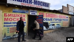 Kyrgyz male labor migrants wait to leave to work in Russia at the office of a company organizing passenger transportation to Russia in Bishkek on Oct. 17, 2023.