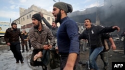 Syrians carry away the body of a man retrieved from the rubble of a building following a regime airstrike on a vegetable market in Syria's last major opposition bastion of Idlib, Jan. 15, 2020.