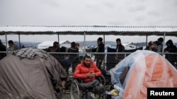 Syrian refugee Radwan Sheikho, 30, is seen among tents at a makeshift camp for refugees and migrants at the Greek-Macedonian border near the village of Idomeni, Greece, March 16, 2016.