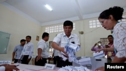 FILE - Members of the National Election Committee count ballots during a Senate election in Phnom Penh, Cambodia, Feb. 25, 2018. The committee was one of several organizations apparently caught up in a recent cyberattack engineered by the Chinese government, investigators allege.