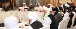 FILE - Undated handout picture of U.S., Taliban and Qatar officials during a meeting for peace talks in Doha, Qatar.
