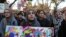 A student holds a sign as she joins a large crowd gathered to protest some of President elect Donald Trump policies and to ask school officials to reject his plans at Rutgers University.