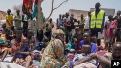 FILE - South Sudanese who fled from Sudan sit outside a nutrition clinic at a transit center in Renk, South Sudan, on May 16, 2023.