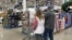 FILE - Shoppers pass displays of goods in a Costco warehouse, Feb. 25, 2024, in Sheridan, Colo. The Trump administration will implement 25% tariffs on Mexican and Canadian goods and a 10% tariff on all Chinese imports on Feb. 1, 2025.