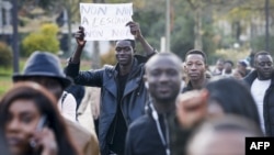 Un homme brandit une affiche mentionnant "Non non à l'esclavage" au cours d'une marche contre "l'esclavage en Libye", Paris, 18 novembre 2017.