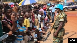 A United Nations peacekeeper watches over crowds that have assembled to greet Pope Francis in Bangui, Central African Republic on, November 29, 2015 (VOA/C. Stein).