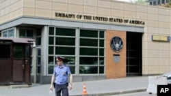 A Russian policeman stands in front of an entrance of the U.S. Embassy in the background in downtown Moscow, Russia, on May 14, 2013. 