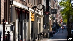 FILE - Sex worker booths, sex shows, clubs, movie theaters, and stores are closed in a near-deserted red-light district in Amsterdam, Netherlands, April 24, 2020, following Dutch government regulations to prevent the further spread of coronavirus.