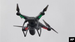 FILE - A drone hovers over the scene of an explosion that leveled two apartment buildings in the East Harlem neighborhood of New York, March 12, 2014.