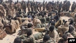 This image made available by the Chadian Army, April 18, 2021, shows alleged rebel soldiers after they were captured following clashes with the Chadian army, in Nyze, Chad, April 17, 2021.