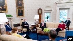  President Joe Biden meets with Transportation Secretary Pete Buttigieg, left, and members of congress to discuss his jobs plan in the Oval Office of the White House in Washington, April 19, 2021.
