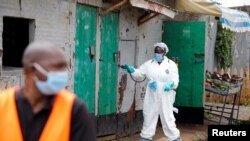 A Nairobi municipality worker sprays disinfectant in an effort to fight against the spread of the COVID-19 in the Kawangware neighborhood of Nairobi, Kenya, May 2, 2020.