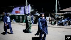 Kenyan police carrying batons and teargas patrol looking for people out after curfew in the Kibera slum in Nairobi, Kenya, March 29, 2020. 