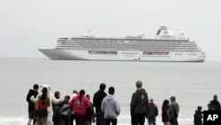 FILE - People prepare to take a polar plunge in the Bering Sea in front of the luxury cruise ship Crystal Serenity, which anchored just outside Nome, Alaska, Aug. 21, 2016. The ship made a port call as it became the largest cruise ship to ever go through the Northwest Passage, en route to New York City.