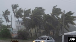 Sebuah mobil melaju di jalan saat Badai Tropis Laura menghantam Guayama, Puerto Rico pada 22 Agustus 2020. (Foto: AFP/Ricardo Arduengo)