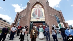 Bishop Ronnie C. Crudup, Sr., of the Mid South Diocese of the Fellowship of International Churches, center, calls for the removal of the Confederate battle flag that occupies the canton portion of the current Mississippi state flag, June 11, 2020.