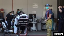 Kru ambulans di luar pintu masuk darurat Rumah Sakit Komunitas MLK selama lonjakan kasus Covid-19 di Los Angeles, California, AS, 26 Desember 2020. (Foto: REUTERS/David Swanson)