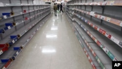 People shop for food from almost empty shelves at a big-box supermarket in Tokyo. Supermarket shelves are running empty despite authorities assuring citizens there is no need to panic from the crisis unfolding at a quake-stricken nuclear power plant, Marc
