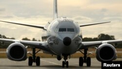FILE - A U.S. Navy P8 Poseidon aircraft returns from a search flight for Malaysia Airlines flight MH370 over the Indian Ocean, at Perth International Airport. A U.S. defense official said further P8 deployments in Singapore could be expected.