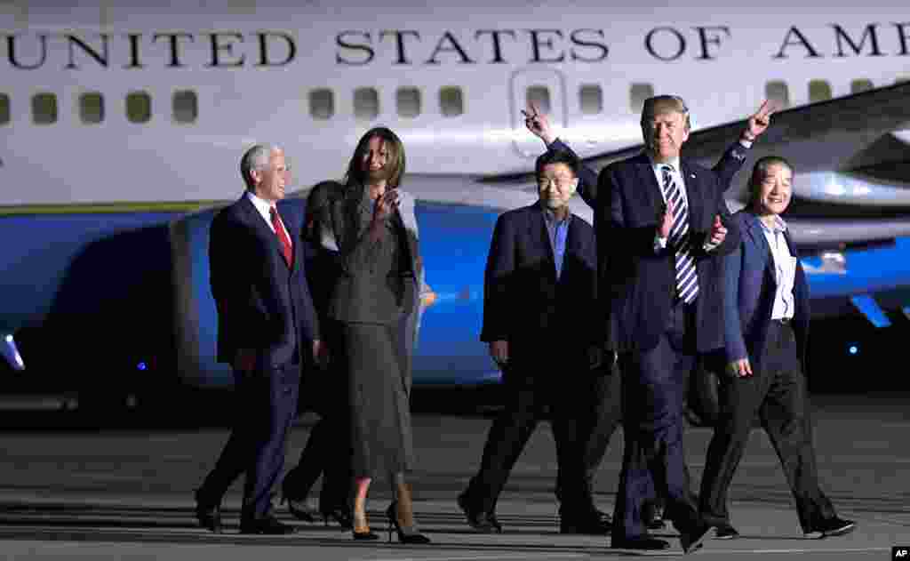 President Donald Trump walks with Tony Kim, third right, Kim Dong Chul, right, and Kim Hak Song, behind Trump, the three Americans detained in North Korea, as they arrive at Andrews Air Force Base in Md., May 10, 2018.