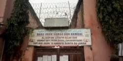 FILE - A sign is seen above a house where police rescued men and boys in Kaduna, Nigeria, Sept. 27, 2019. The sign reads: "Imam Ahmad Bun Hambal center for Islamic studies."