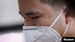 A man wearing a face mask cries in Wuhan, Hubei province, as China holds a national mourning for those who died of COVID-19 on the Qingming tomb-sweeping festival April 4, 2020. 