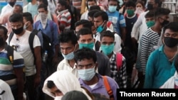 Migrants who returned from their hometown wait in line to be tested for the coronavirus disease (COVID-19) during a rapid antigen testing campaign at a railway station on the outskirts of Mumbai, India, Oct. 3, 2020. 