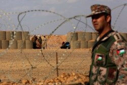 FILE - A Jordanian soldier stands guard at the northeastern border with Syria, close to the informal Rukban camp for displaced Syrians, Feb. 14, 2017.