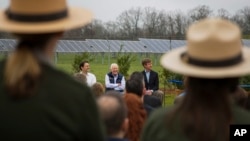 FILE - Former President Jimmy Carter, center, sits with his grandson Jason Carter, left, and George Mori, executive vice president at SolAmerica Energy during a ceremony for a solar panel project on Jimmy Carter's farmland in his hometown of Plains, Ga., Feb. 8, 2017.