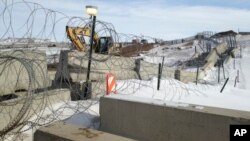 FILE - Razor wire and concrete barriers protect access to the Dakota Access pipeline drilling site, Feb. 9, 2017, near Cannon Ball, North Dakota.