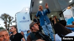 Turkish President Recep Tayyip Erdogan makes a speech protected by bodyguards in Istanbul, July 16, 2016. 