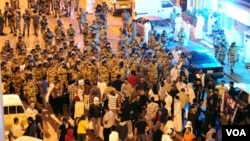 Polisi anti-huru hara menghadap para demonstran di Awwamiya, Arab Saudi pekan lalu.