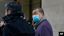 FILE - Hong Kong pro-democracy activist and media tycoon Jimmy Lai, right, leaves the Court of Final Appeal during a break in Hong Kong, Dec. 31, 2020. 