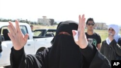 A Syrian woman, who has relatives in the Syrian city of Deraa, gestures at the Jordanian side of the border with Syria that has been closed, April 25, 2011