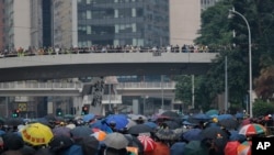 Protesters shield behind umbrellas as they prepare to face off with police in Hong Kong, Sept. 29, 2019. 