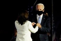Presiden terpilih Joe Biden disambut di atas panggung oleh Wakil Presiden terpilih Kamala Harris sebelum dia berbicara di Wilmington, Delaware, Sabtu, 7 November 2020. (Foto: AP/Paul Sancy)