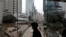 FILE - A woman walks on a bridge near the Central district of Hong Kong, Wednesday, Feb. 24, 2016. More than 10,000 people wrote to TVB to complain about the subtitles.