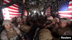 U.S. Marines are seen on board a helicopter at Kandahar air base upon the end of operations for the Marines and British combat troops in Helmand province, Oct. 27, 2014. 