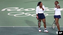 Venus Williams (kanan) dan adiknya Serena dalam pertandingan ganda tenis putri di Olimpiade Rio de Janeiro 2016. (AP/Charles Krupa)