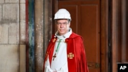 FILE - Archbishop of Paris Michel Aupetit arrives to attend a ceremony to celebrate Good Friday in a secured part of Notre-Dame de Paris cathedral, April 10, 2020, in Paris. 