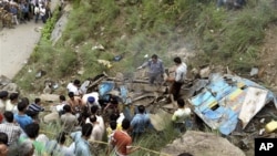 Para petugas sedang melakukan pencarian korban di dekat bagian bis yang terjungkal ke jurang di negara bagian Himacal Pradesh, sekitar 620 kilometer utara New Delhi, India (11/8). 