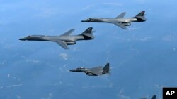 FILE - In this June 20, 2017, file photo provided by South Korean Defense Ministry, U.S. Air Force B-1B bombers, top, and second from top, and South Korean fighter jets F-15K fly over the Korean Peninsula, South Korea. A South Korean lawmaker said Oct. 10, 2017, that North Korean hackers may have stolen highly classified military documents that include U.S.-South Korean wartime "decapitation strike" plans against the North.